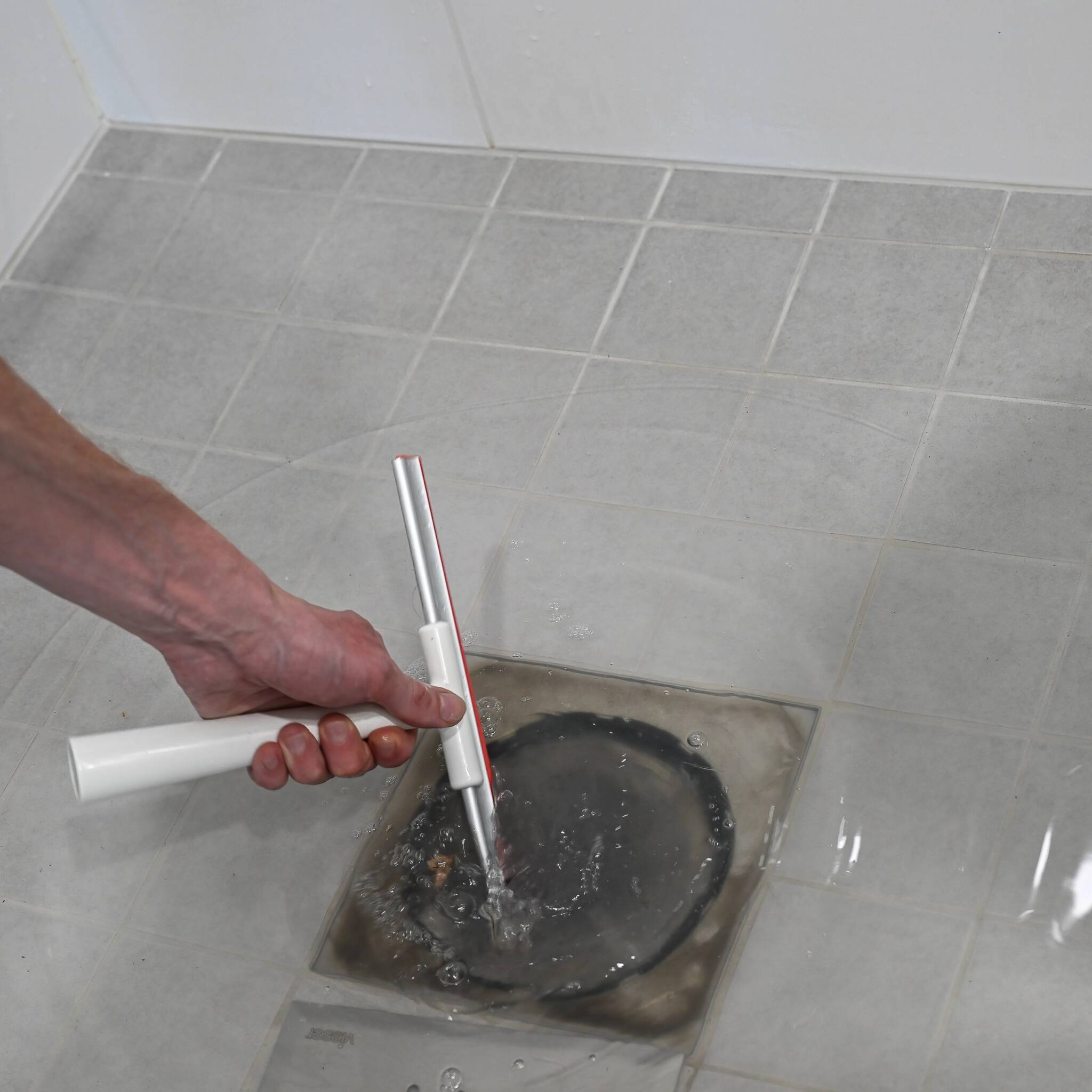 Technician fixing a clogged drain.